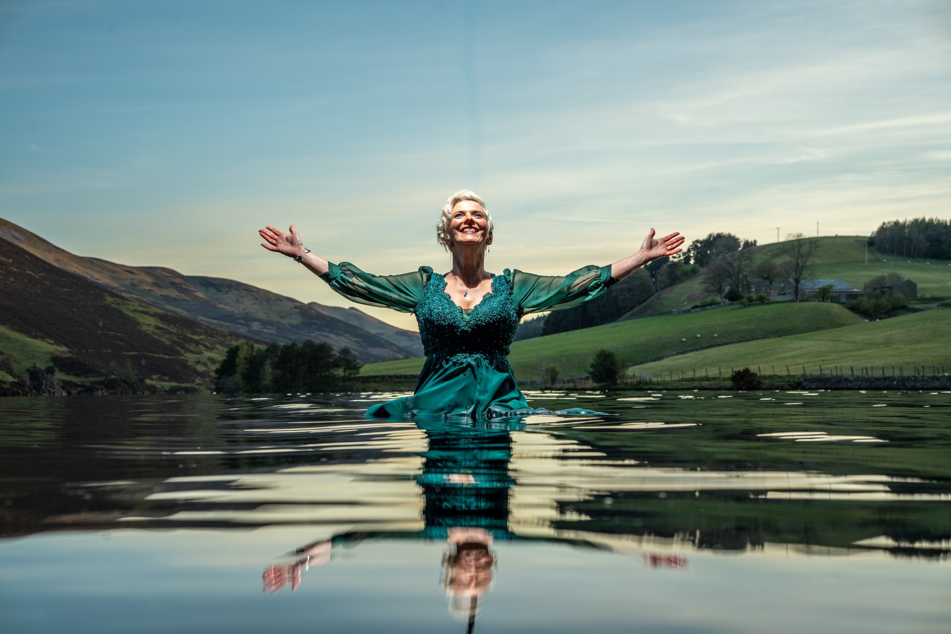 Emma Morwood in water with hands outstretched and reflection